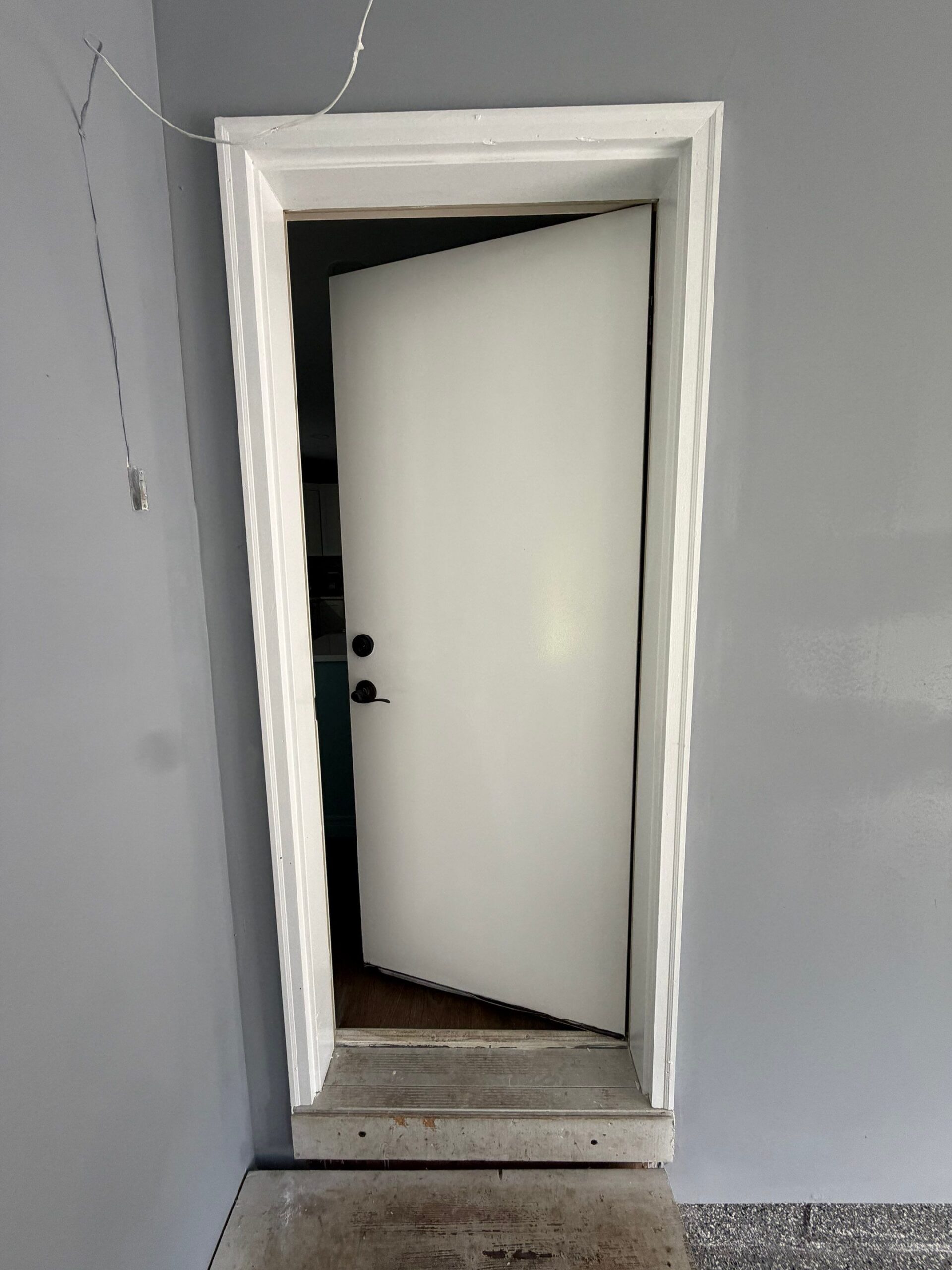 Freshly painted white door frame and light grey interior wall