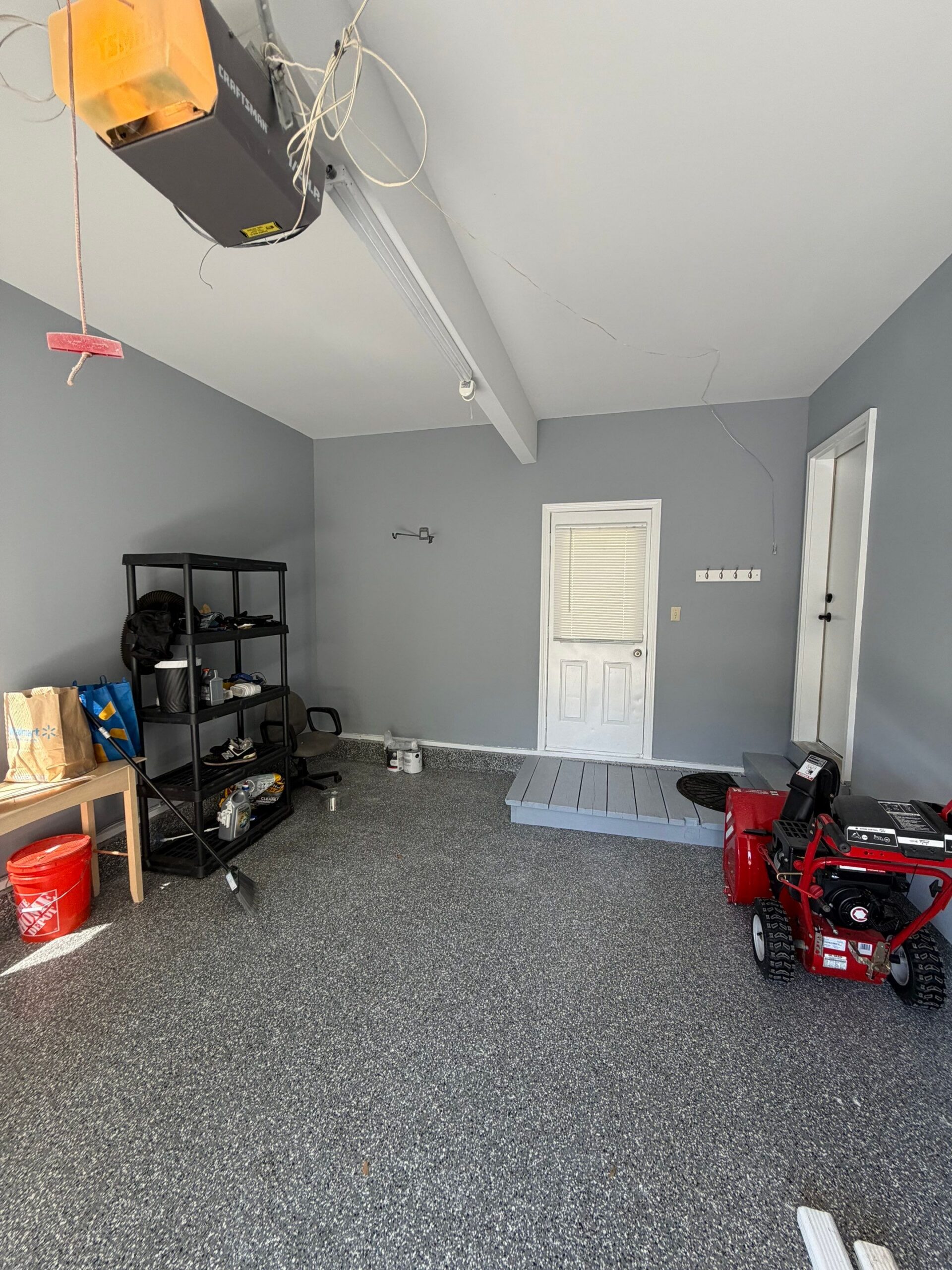 Finished residential garage interior with painted grey walls and epoxy floor