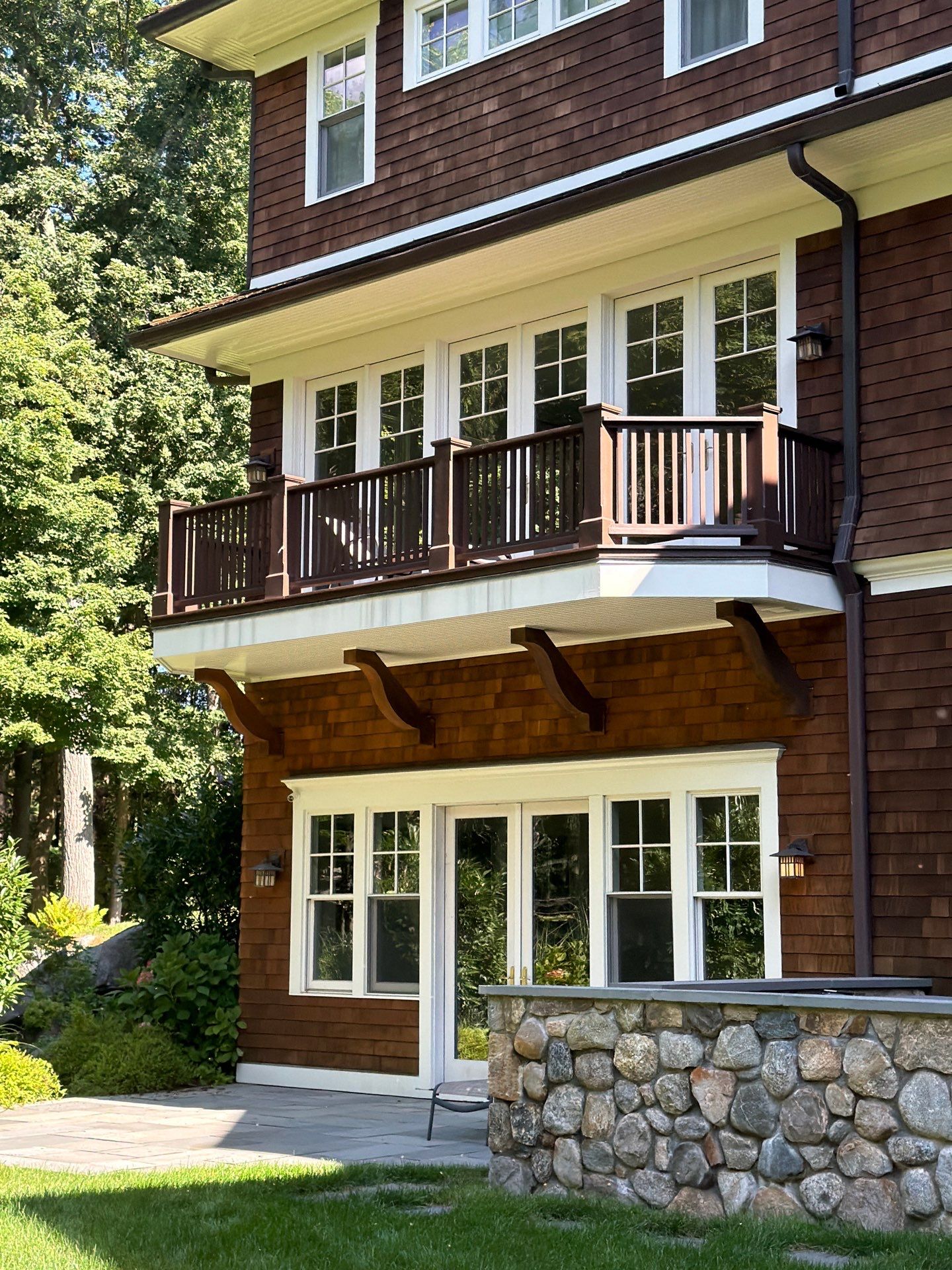Custom stained wooden eaves and rafter tails on a modern Connecticut home exterior