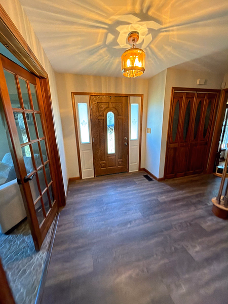 Foyer featuring wood panel doors, vinyl flooring, and glass French doors