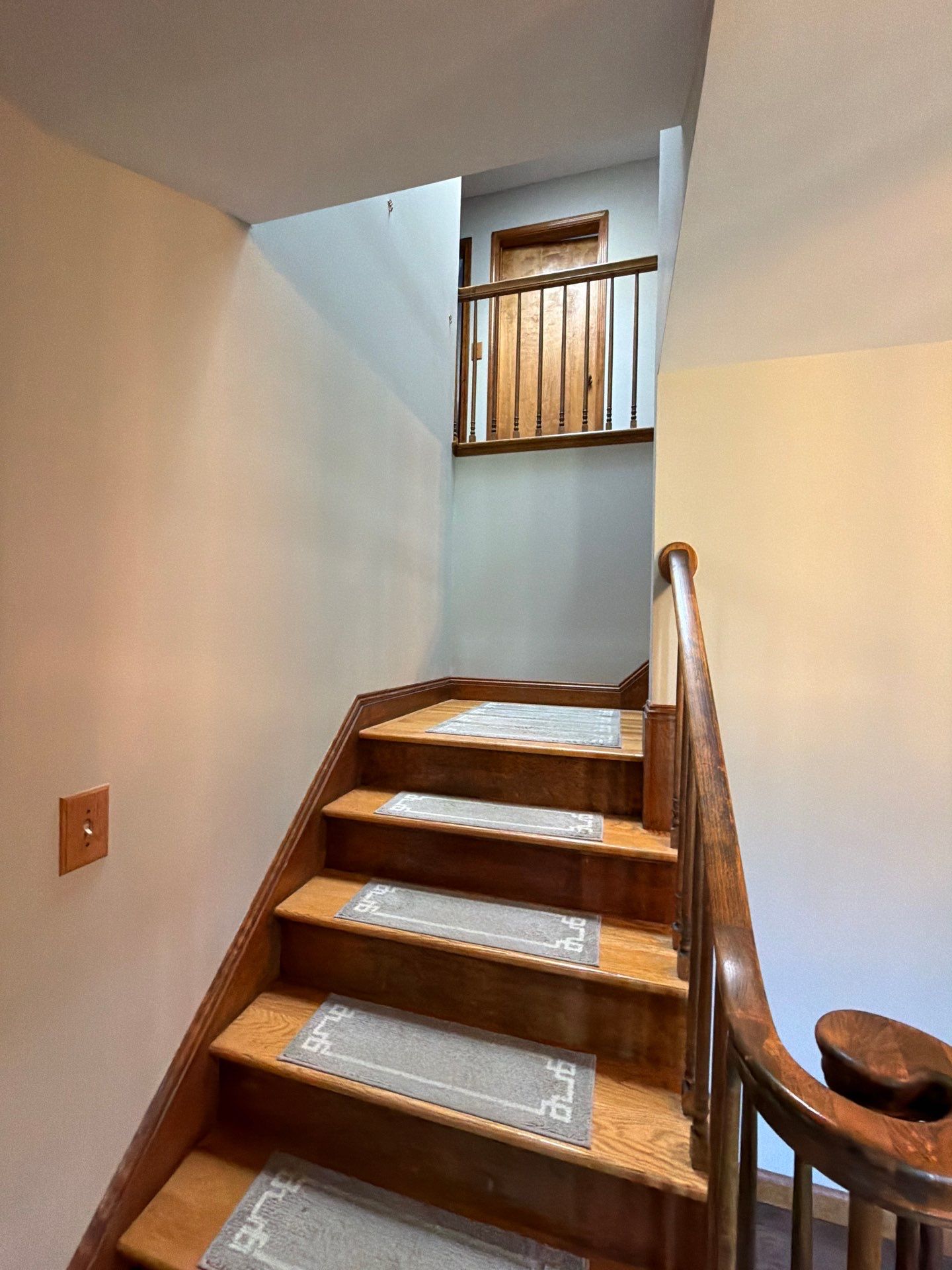 Wooden staircase with step treads leading up to a second floor landing