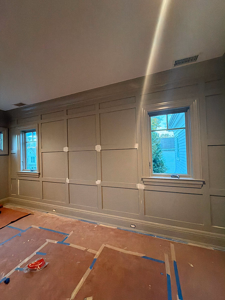 Interior room wall with wainscoting trim prepped with painter tape