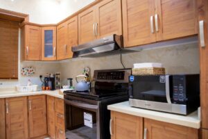 Modern kitchen with light wood cabinetry, countertop, and appliances